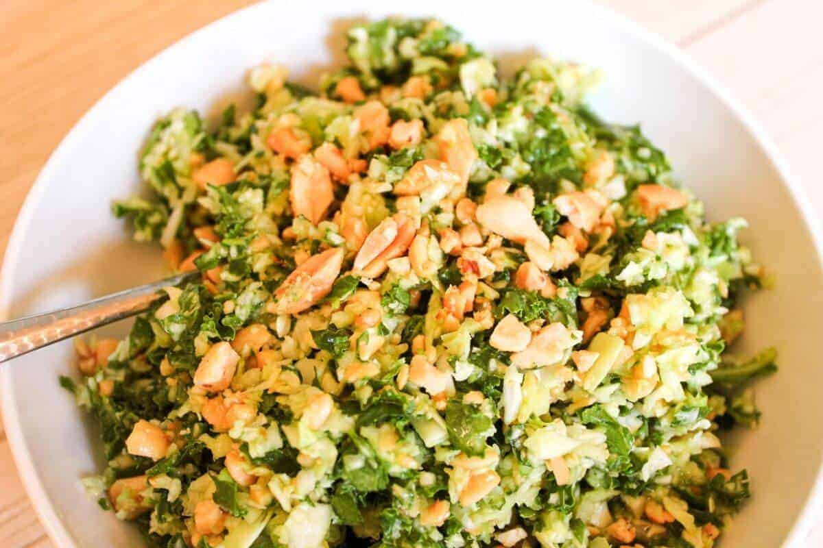 Thai peanut salad dressing on a cabbage and kale salad in a bowl