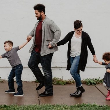 Young family walking down a sidewalk together